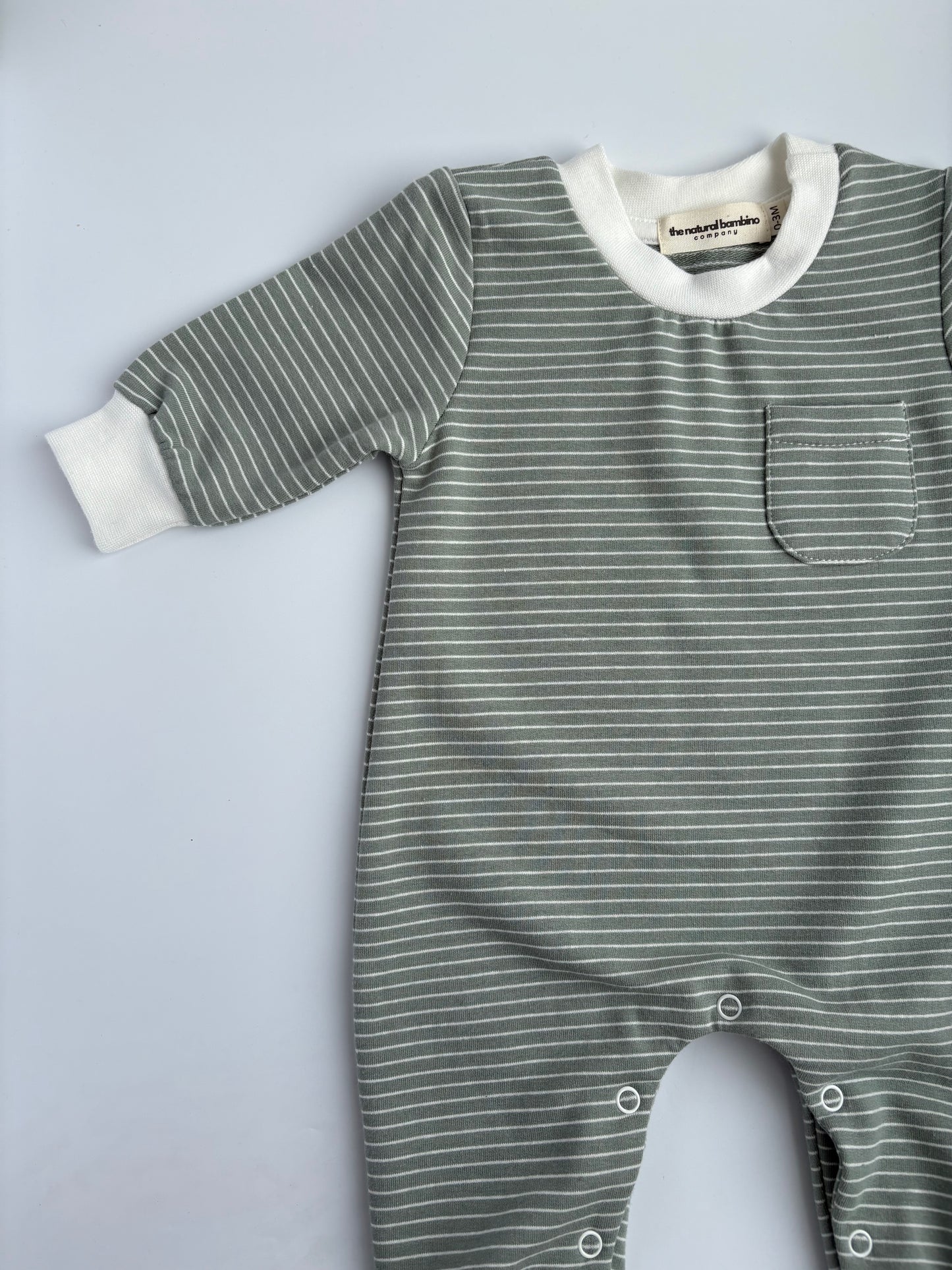 green striped sleepsuit laid on a white background