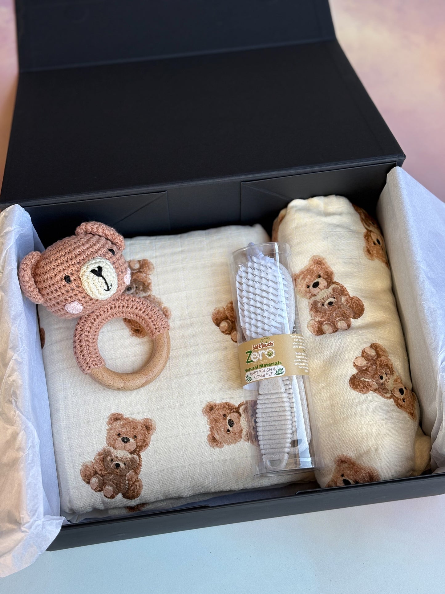 black gift box containing a baby brush set and cute bear items