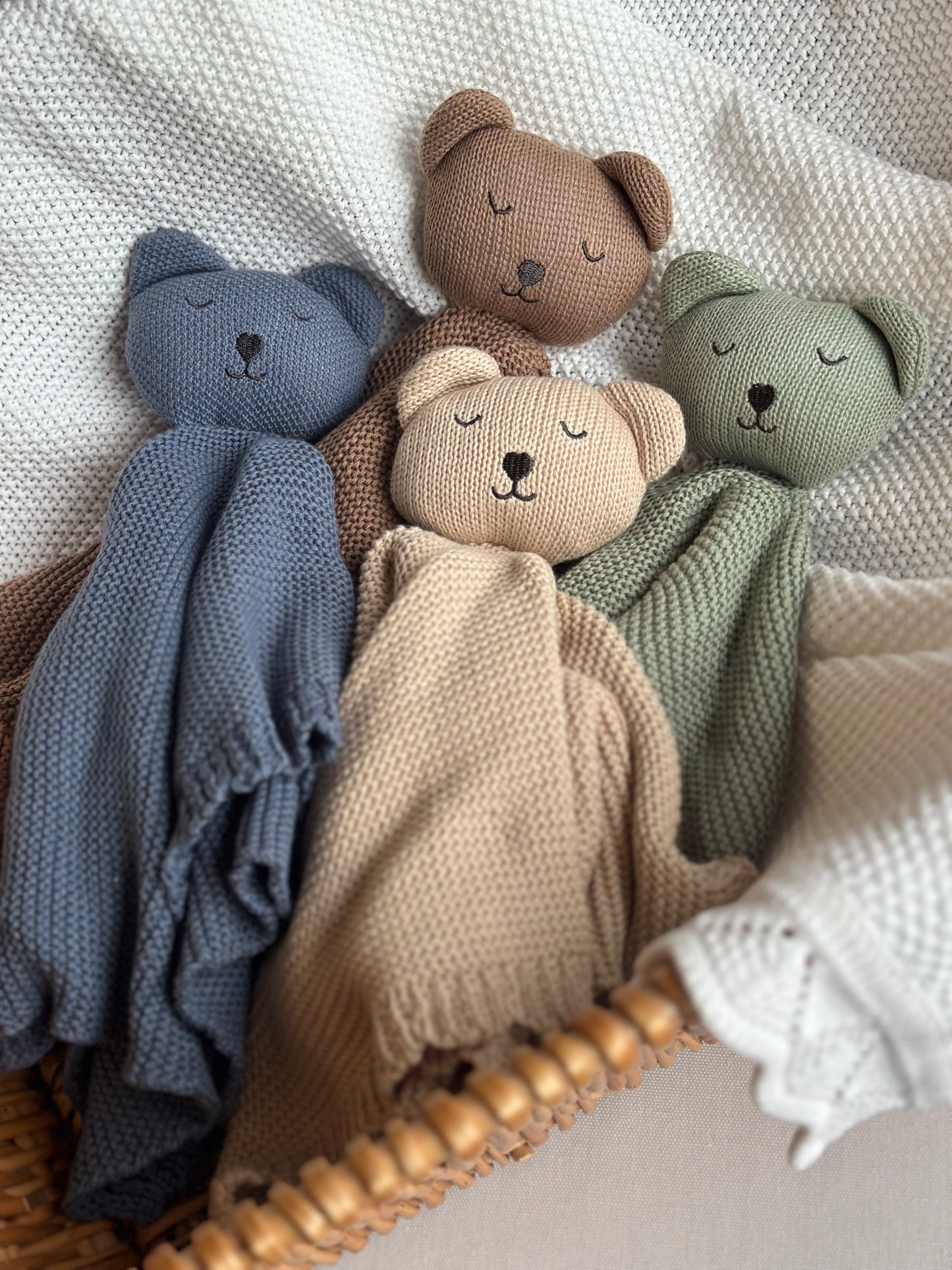 4 organic cotton comforters laid in a wicker basket with a white blanket