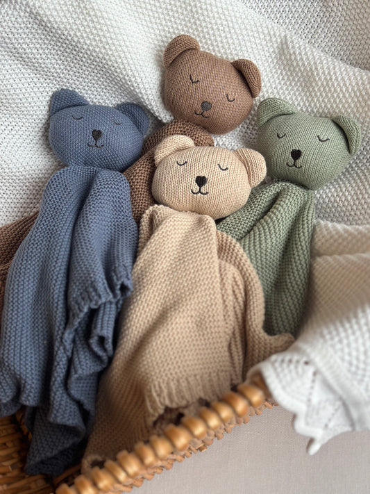 4 organic cotton comforters laid in a wicker basket with a white blanket