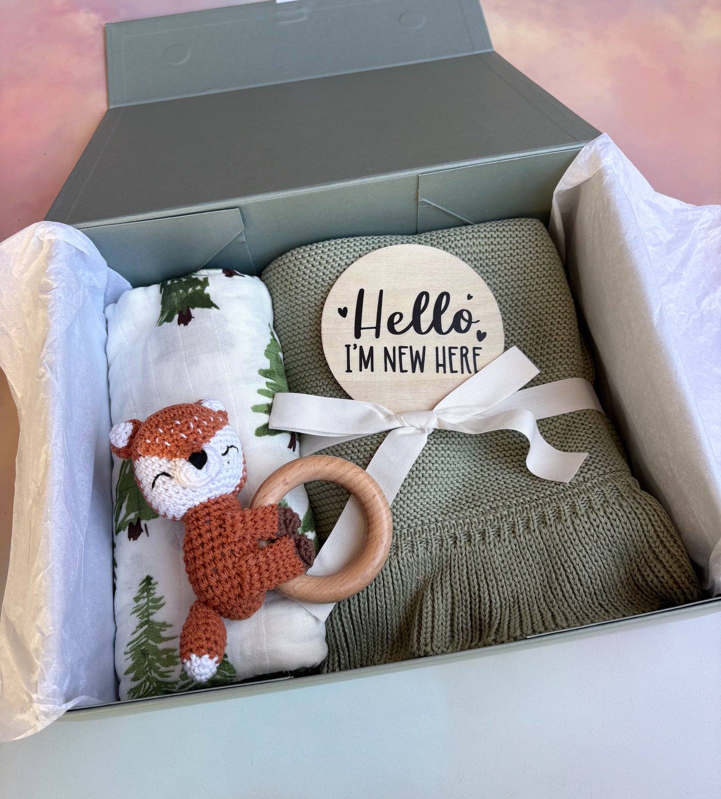 Sage green baby gift box filled with 4 cute baby items