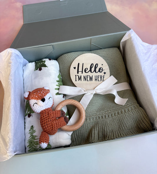 Sage green baby gift box filled with 4 cute baby items
