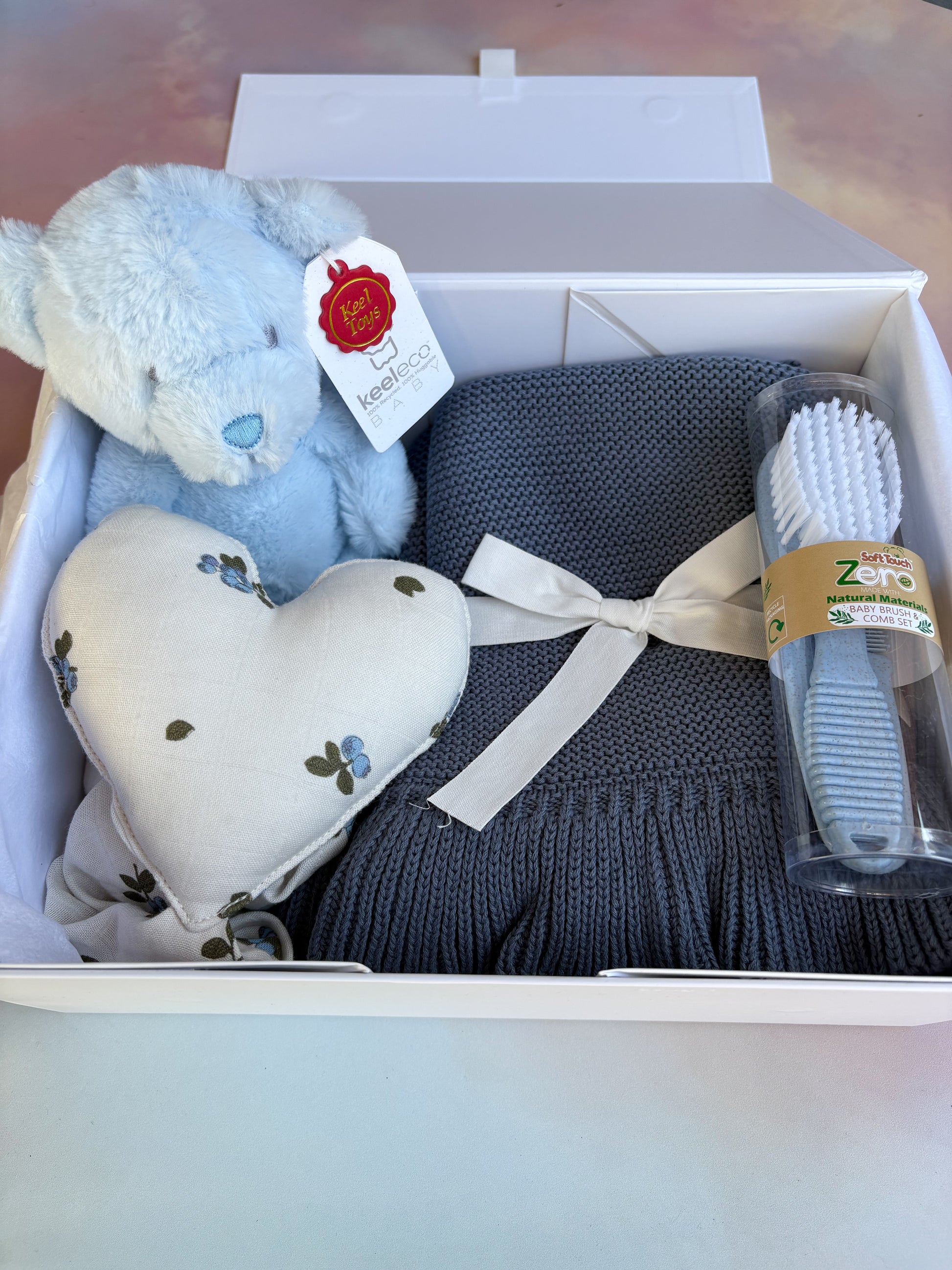 White baby gift box filled with 4 eco-friendly baby items