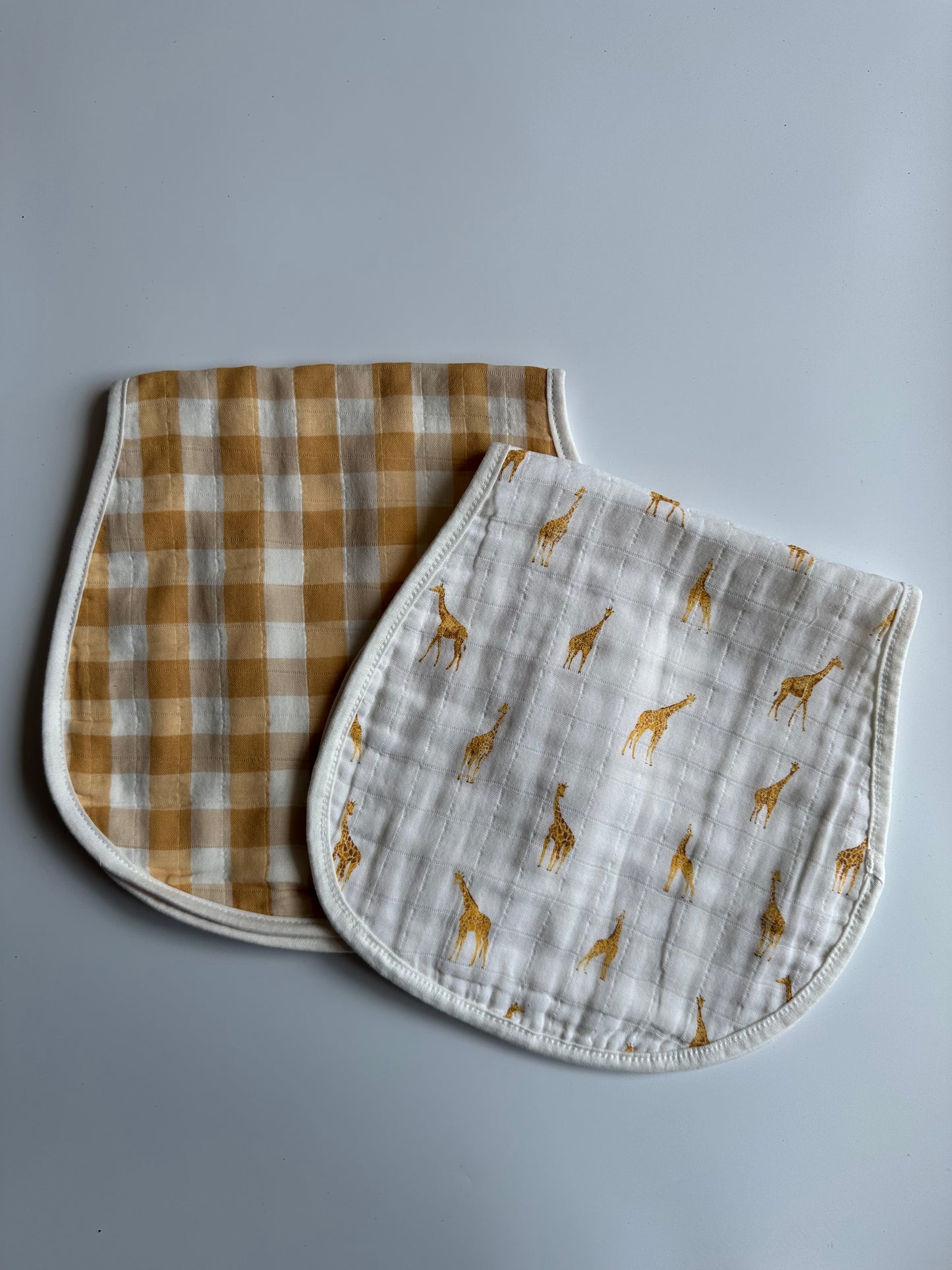 Set of safari theme muslin burp cloths, folded in half on a white background